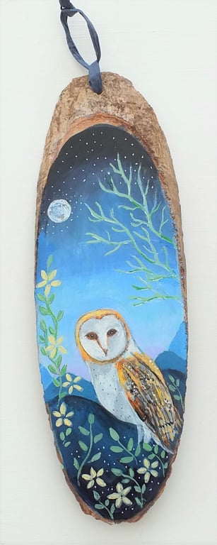 Barn owl by moonlight on  a wood slice 