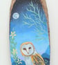 Barn owl by moonlight on  a wood slice 