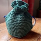 Hand knitted 2 pint (4 cup) tea cosy in Bottle Green with matching pom poms