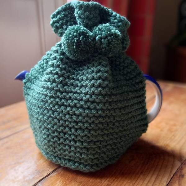 Hand knitted 2 pint (4 cup) tea cosy in Bottle Green with matching pom poms