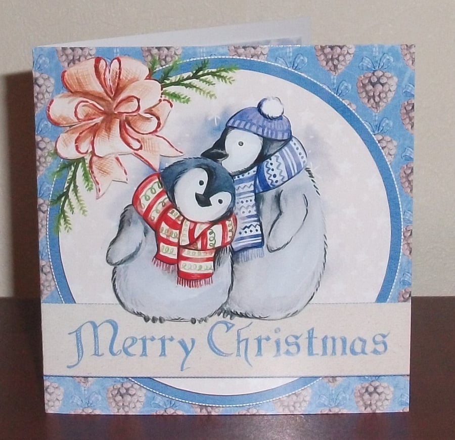 Christmas card with cute penguins in hats and scarves