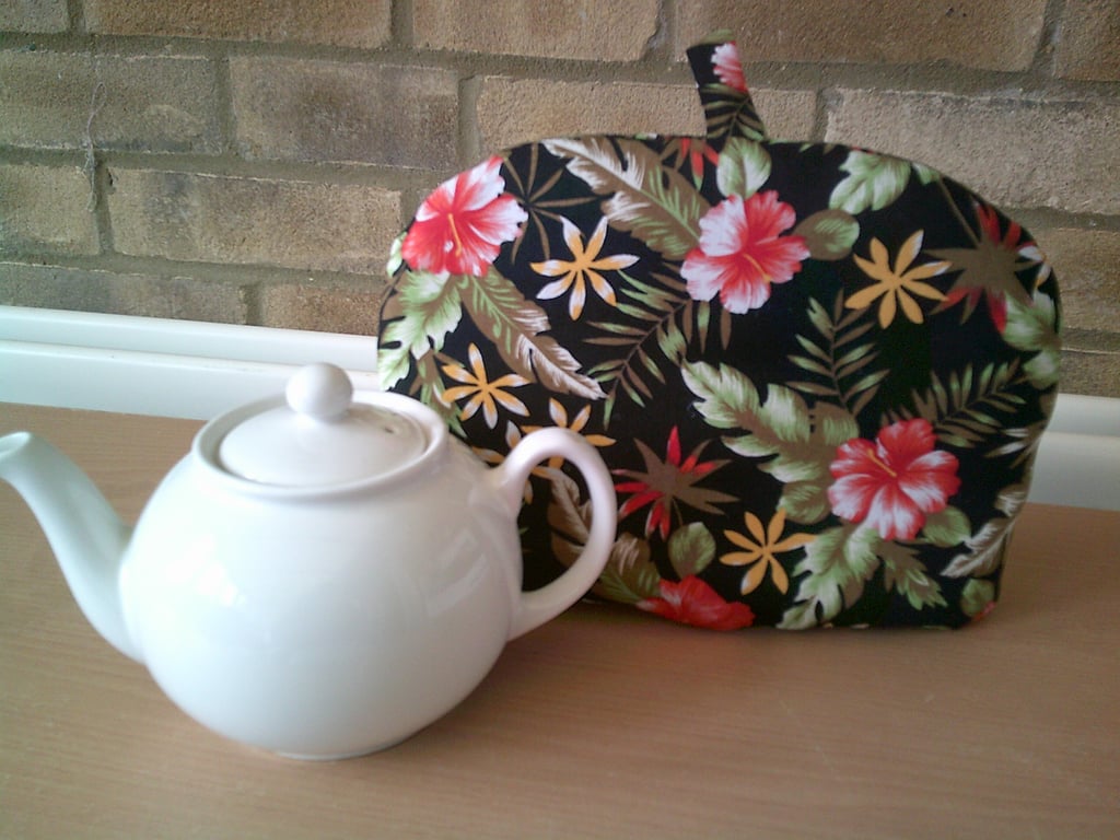Small Tea Cosy with Red Hibiscus Flowers on a Black Background