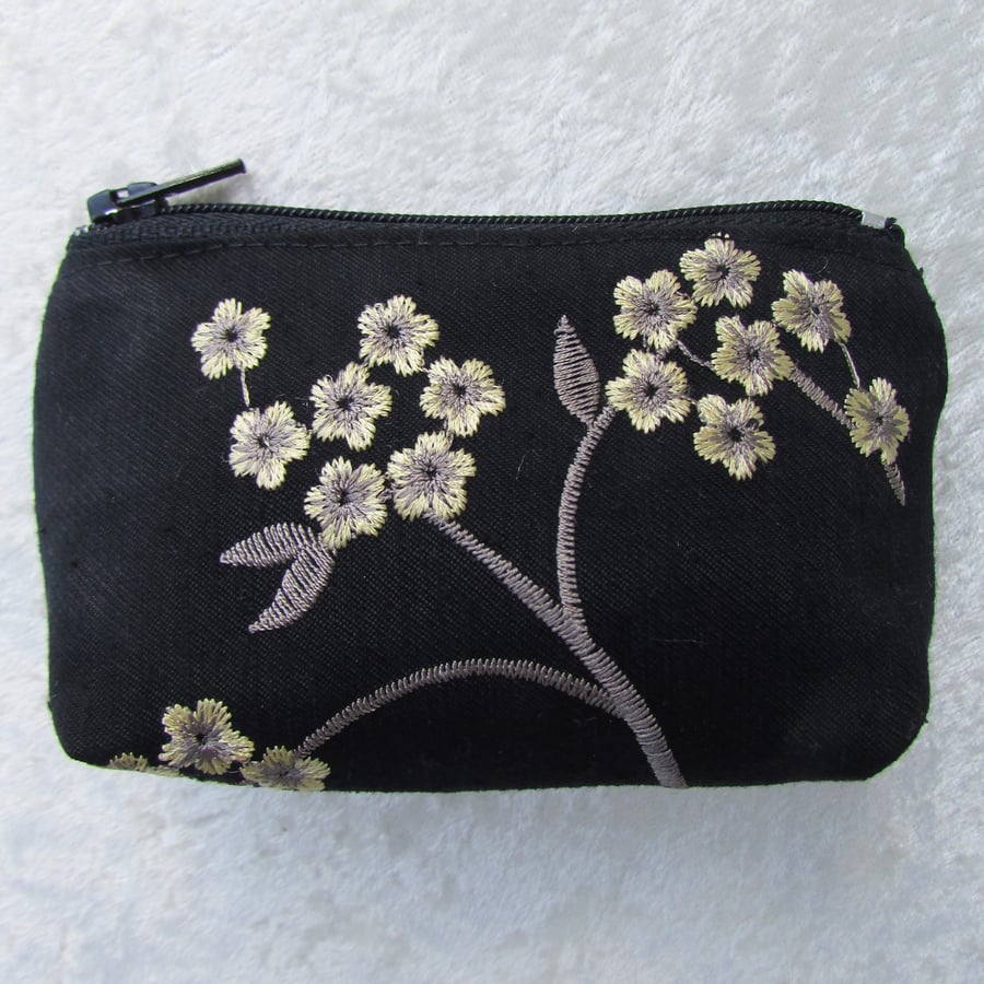 Black purse with sprays of pale yellow flowers
