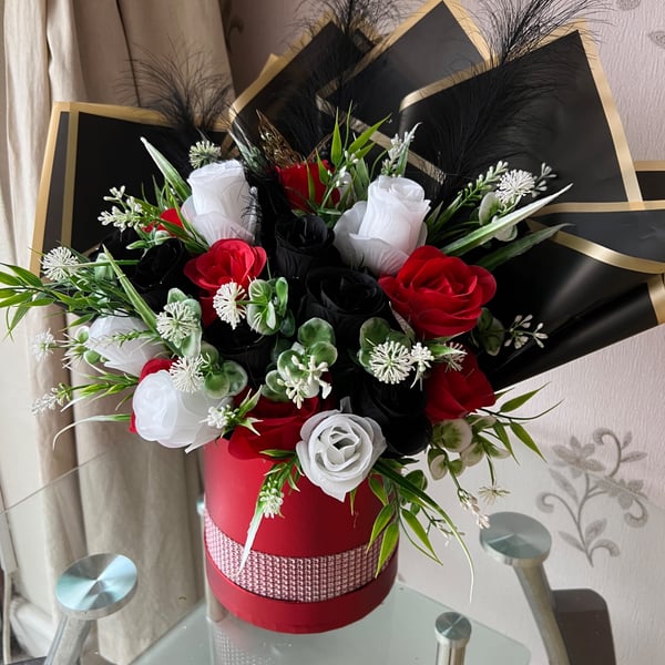 Red hatbox with red, white and black roses