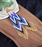 Handmade beadwork fringe earrings in a blue and copper chevron design
