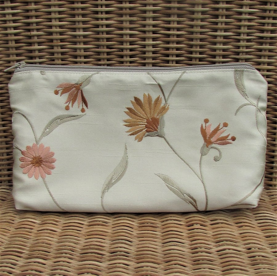 Cosmetic bag in embroidered gold fabric with floral pattern