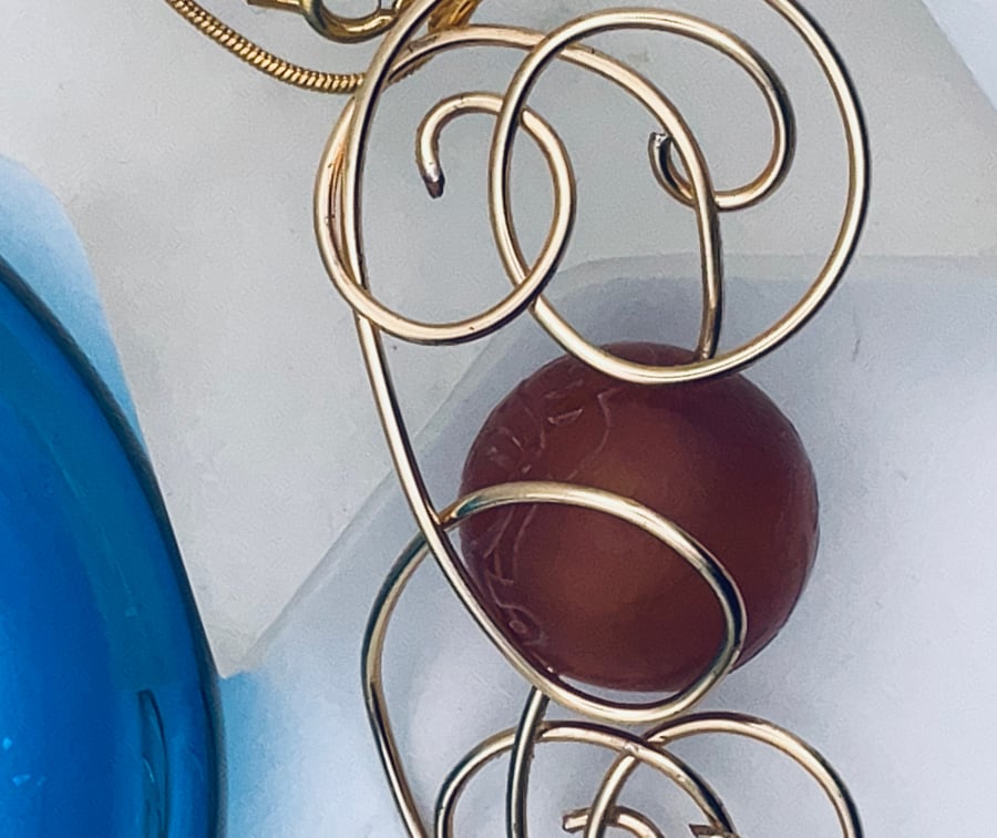 Cheery carnelian large bead pendant in golden swirls