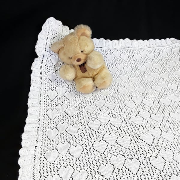 Pure white hand knitted lacy baby christening shawl with hearts pattern. 