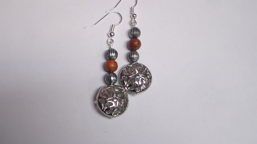 Flat silver round bead earrings.