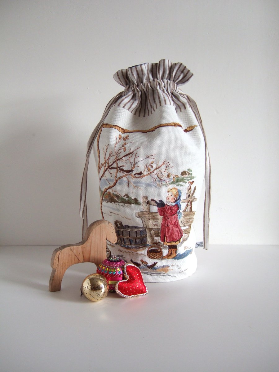 A child's Christmas santa sack or reusable wrapping in vintage embroidery.