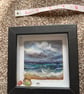 Beach scene cloudy sky, waves and sand needle felt black frame Seaglass shells