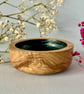 Small, hand-turned wooden dish with vibrant aqua grain detail.