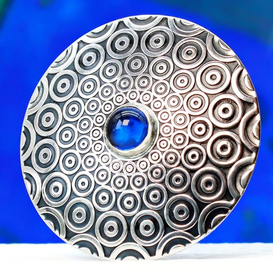 Handmade brooch, descending circle pattern and a beautiful blue Spinel gemstone