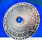 Handmade brooch, descending circle pattern and a beautiful blue Spinel gemstone