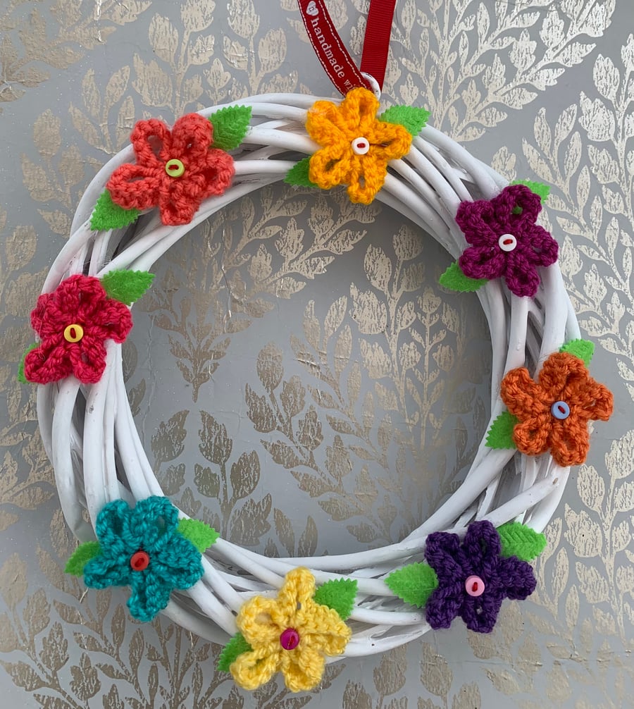Knitted flower wreath on wicker base, spring wreath 