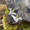 Silver bird earrings with green beads.
