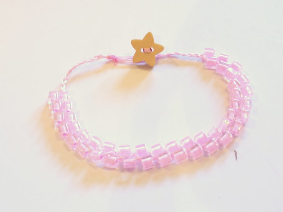 Pink beaded bracelet with wooden star button.