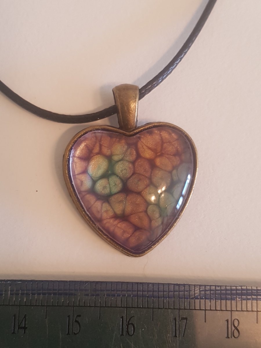 Heart shaped pendant,with tones of purple, green and orange 