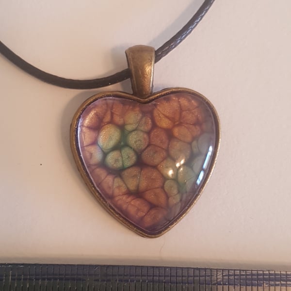 Heart shaped pendant,with tones of purple, green and orange 
