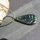 Metallic green and bronze fern tear-drop pendant on a green woven cord.
