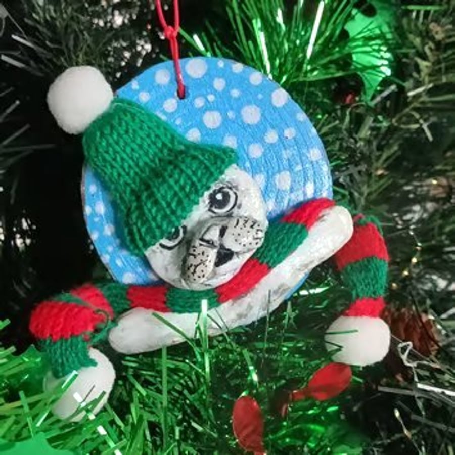 Image of Christmas tree decoration of a Seal, airdry clay with a fabric hat and scarf.  