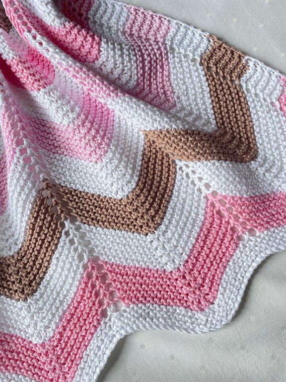 Pink white and chocolate brown, hand knitted baby blanket.