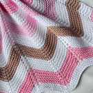 Pink white and chocolate brown, hand knitted baby blanket.