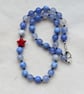 Blue fire agate knotted necklace with red howlite star 