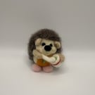 Handmade needle felted hedgehog baking a cake wearing an apron and pink slippers
