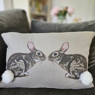 Handmade taupe-grey linen cushion with sewn printed rabbit & fluffy pompom tails
