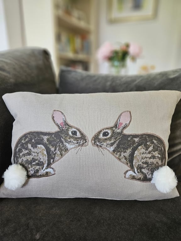 Handmade taupe-grey linen cushion with sewn printed rabbit & fluffy pompom tails