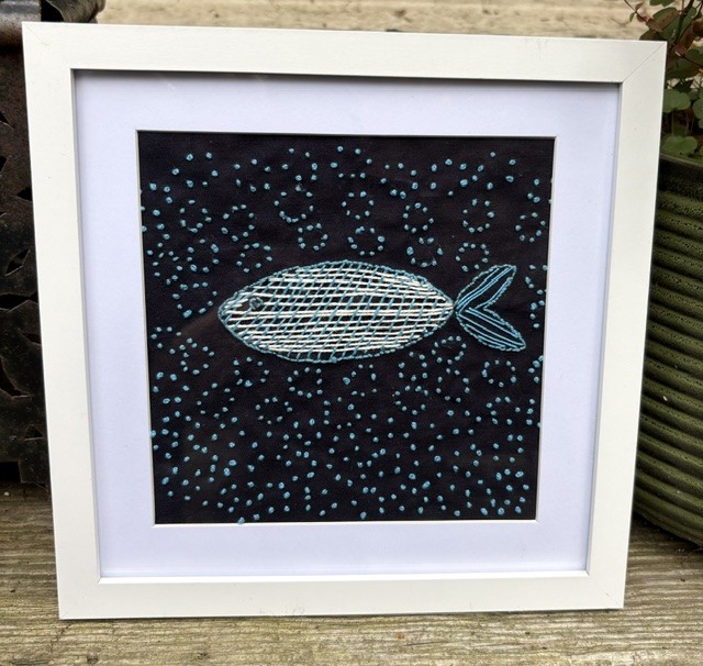 Hand embroidered fish in the sea.