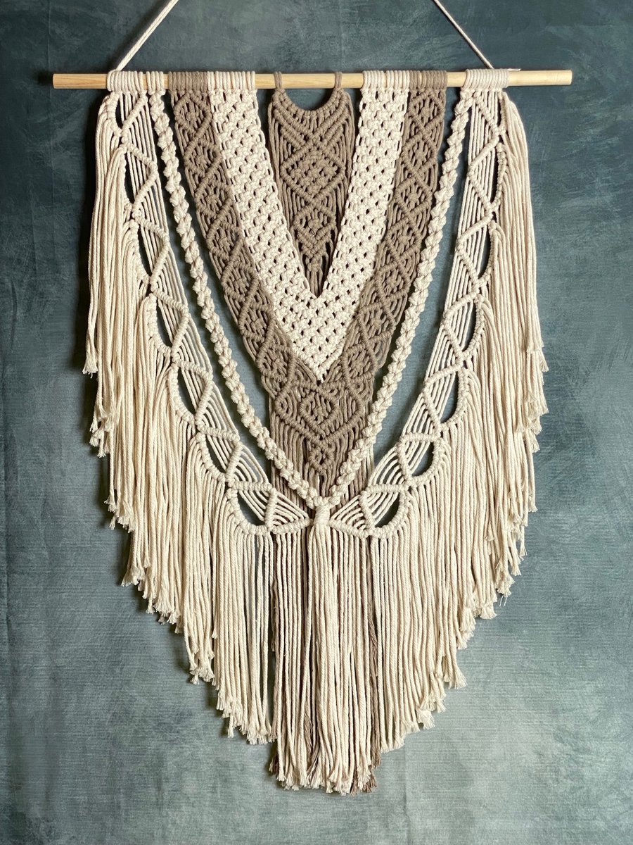 Macrame wall hanging with intricate knot design, stone and beige colours