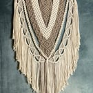 Macrame wall hanging with intricate knot design, stone and beige colours