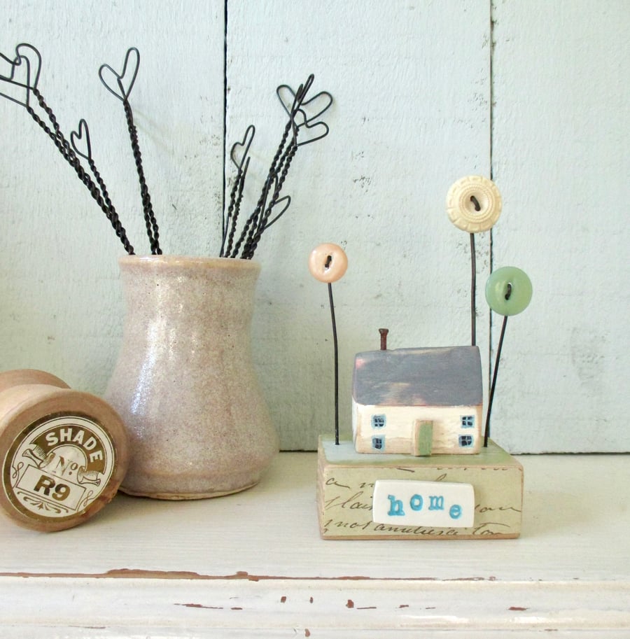 Little wooden painted house with button flower garden 'home'