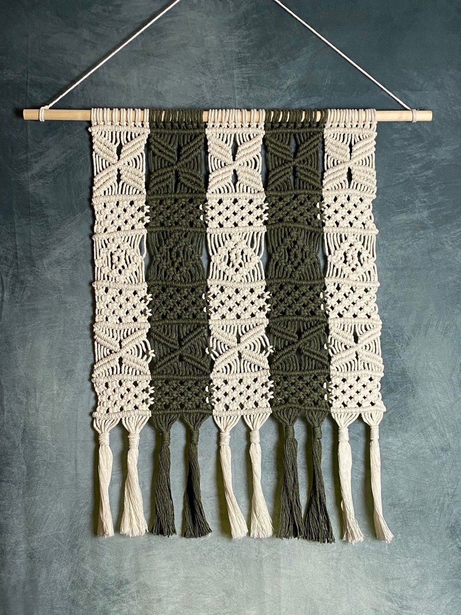 Macrame wall hanging with intricate knot design, dark green and beige colours