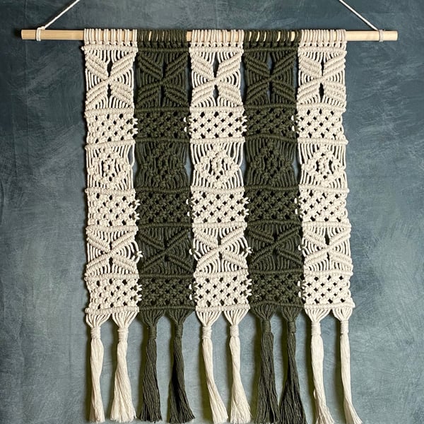 Macrame wall hanging with intricate knot design, dark green and beige colours