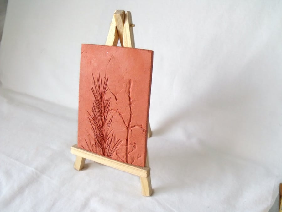 terracotta impressed clay tile displayed on an easel, 3 x 5 inches