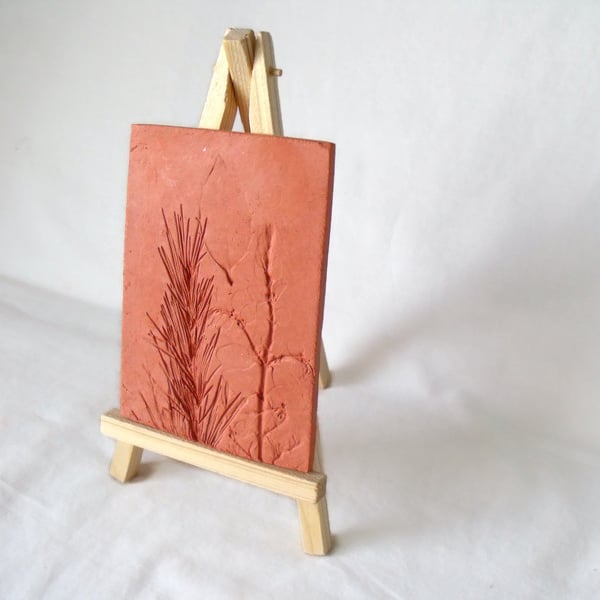 terracotta impressed clay tile displayed on an easel, 3 x 5 inches