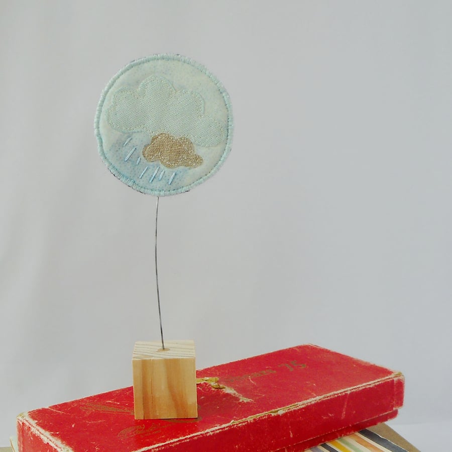 Embroidered Raincloud fabric ornament on wooden block