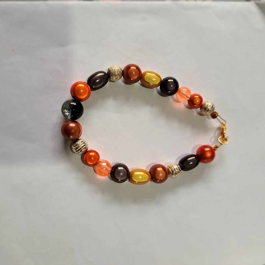 Disco beaded wired bracelet, brown, orange, black with silver ball spacers.