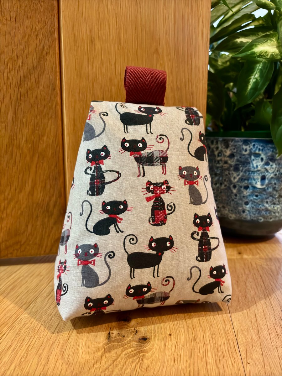 Cotton fabric doorstop in fun tartan cat print, filled with pebbles.