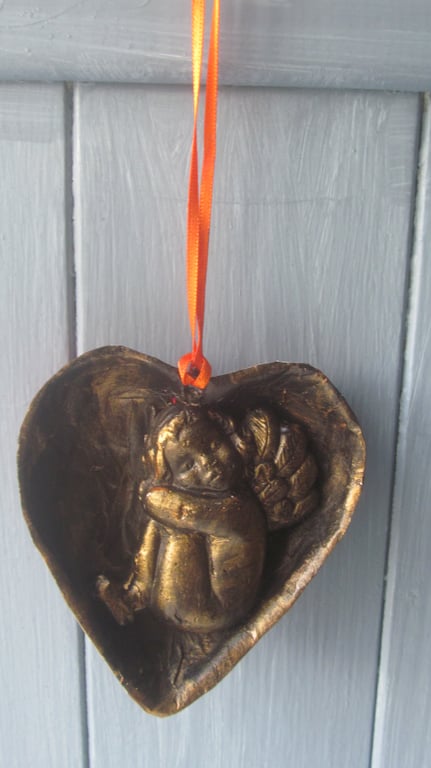 Cherub asleep in a heart decoration