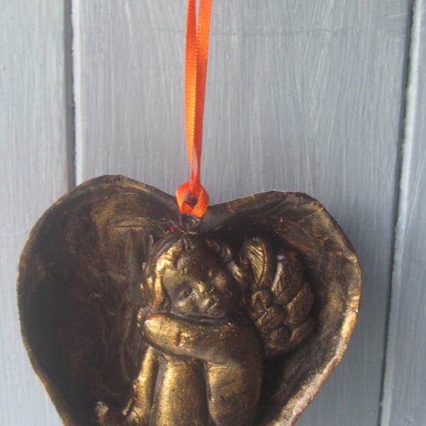 Cherub asleep in a heart decoration