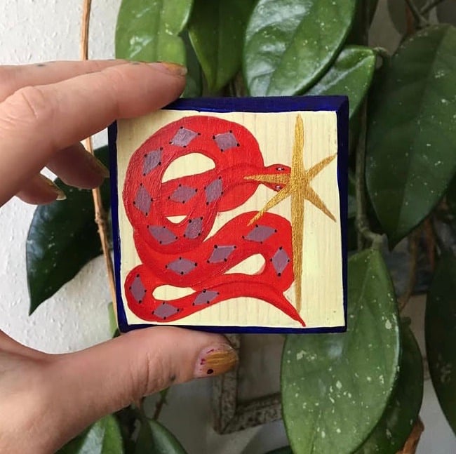 Harlequin, red snake painting on wood in the style of an icon