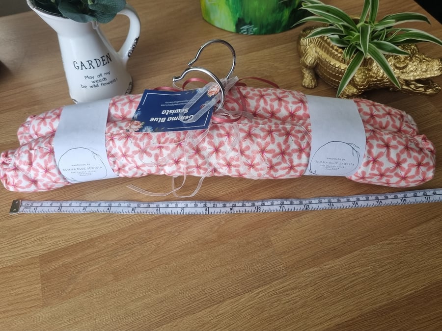 Pair of padded covered clothes hangers. Ivory with peachy pink print.