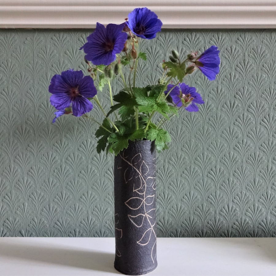 Stylish ceramic vase with freeform foliage motifs, black and white finish.