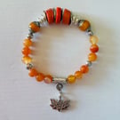 Semiprecious stone charm bracelet featuring deep sea coral and carnelian