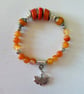 Semiprecious stone charm bracelet featuring deep sea coral and carnelian