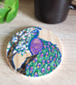 Wooden coaster handpainted with a colourful Peacock bird next to a cherry tree.